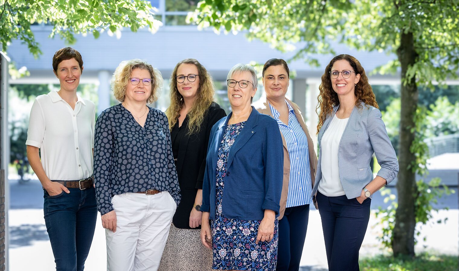 Sechs Frauen des Teams „Wegweiser Weiterbildung Nordostniedersachsen“ im Außenbereich vor grünem Hintergrund